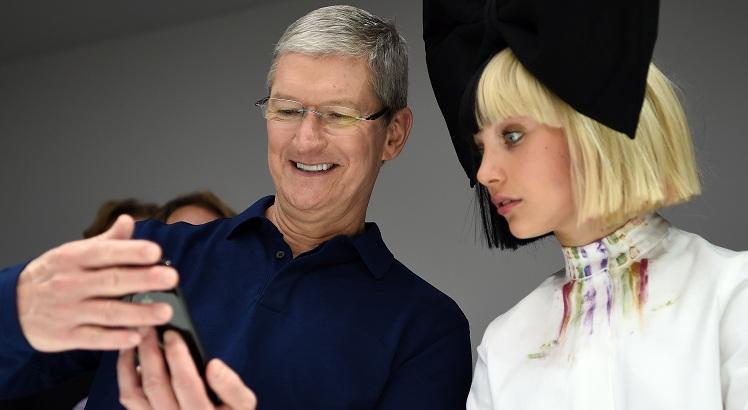 TOPSHOT - Apple CEO Tim Cook (L) shows dancer Maddie Ziegler (R) a new iPhone during a product demonstration at Bill Graham Civic Auditorium in San Francisco, California on September 07, 2016.   / AFP / Josh Edelson