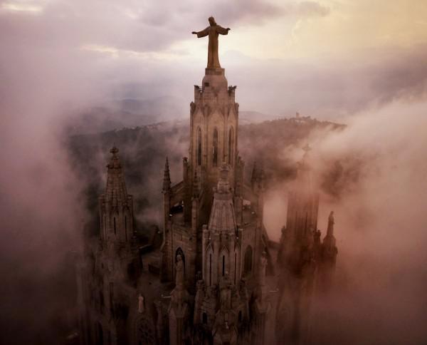 Nuvens rondam os pilares da Igreja Cor Sagrat, no alto de uma colina acima de Barcelona, na Espanha