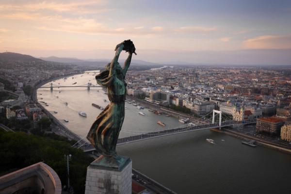 A estátua da liberdade varrida pelo vento, com vista para Budapeste