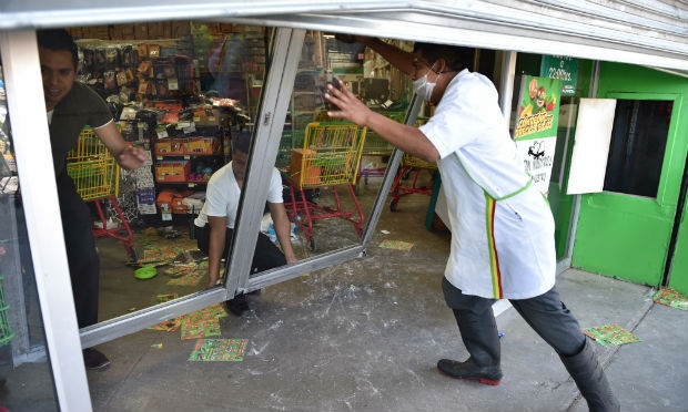 Lojistas tentam fechar lojas para evitar mais saques.  / Foto: YURI CORTEZ / AFP