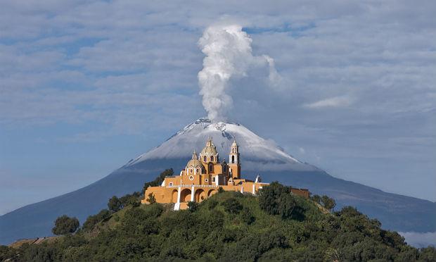 O impressionante cenário exibe o vulcão ao fundo e o santuário de Nossa Senhora dos Remédios, construído sobre gigantesca base piramidal em Cholula / Foto: Ricardo Espinosa-reo/divulgação