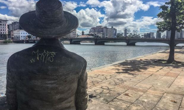 Estátua de Ascenso Ferreira, importante poeta modernista, observa o Rio Capibaribe enquanto o monumento sofre com a ação dos vândalos / Foto: Ingrid Cordeiro / NE10
