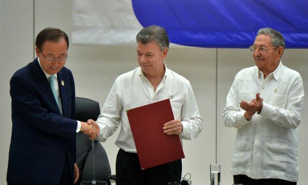 O presidente colombiano, Juan Manuel Santos, e o líder das Farc, Timoleon Jimenez, assinaram o acordo e trocaram um aperto de mãos durante uma cerimônia, em Cuba, ao lado de líderes internacionais. / Foto: Adalberto Roque / AFP