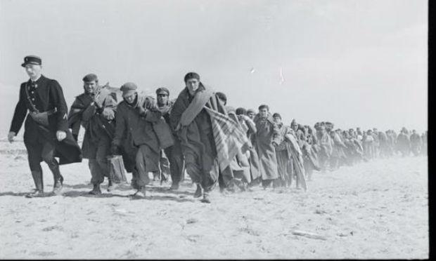 Refugiados andando na praia, no campo de internação francês para exilados republicanos, em março de 1939. / Foto:  Robert Capa