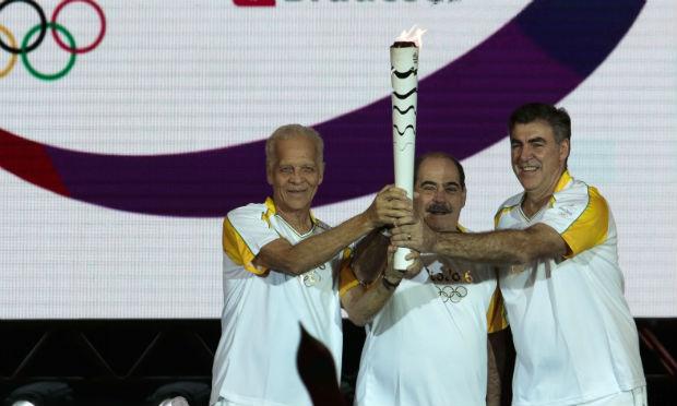 Ademir da Guia, Rivellino e Zetti seguram a Tocha Olímpica. / Foto: AFP.