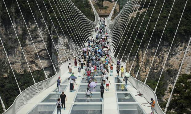 A ponte de seis metros de largura é formada por 99 placas de vidro transparentes e pode receber, simultaneamente, 800 pessoas, informou a agência de notícias oficial Xinhua. / Foto: Fred Dufour / AFP