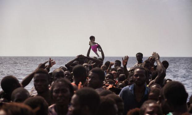 As imagens de Messinis são um testemunho comovente, com centenas de pessoas, entre elas crianças e mulheres, aterrorizadas e abarrotadas em um barco de madeira e em botes infláveis. / Foto: Aris Messinis / AFP