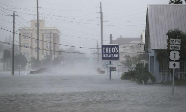 As estradas e avenidas estavam desertas, as lojas fechadas e não se via uma pessoa na rua inundada / Foto: AFP